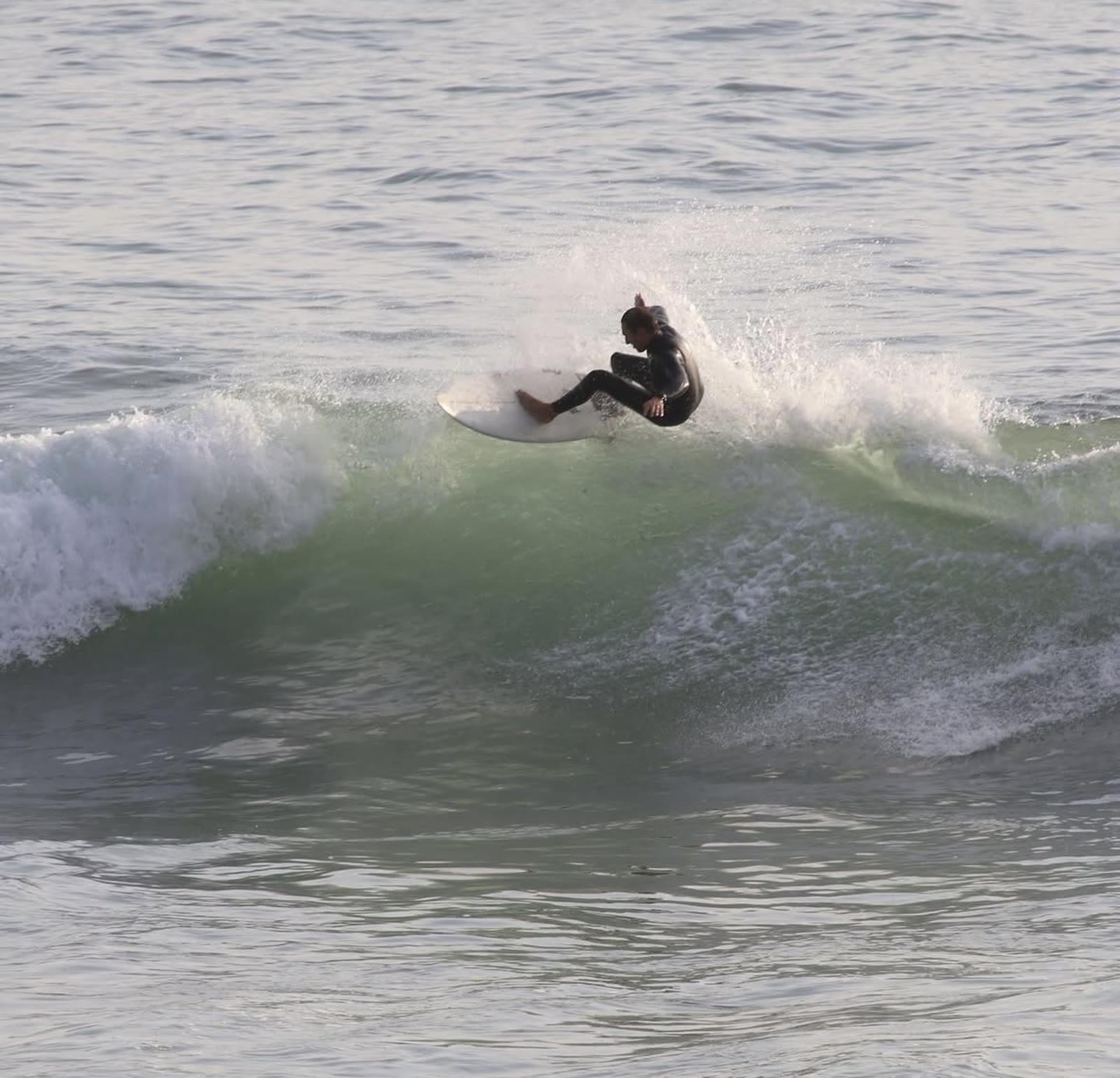 Surfer carving on a clean green wave