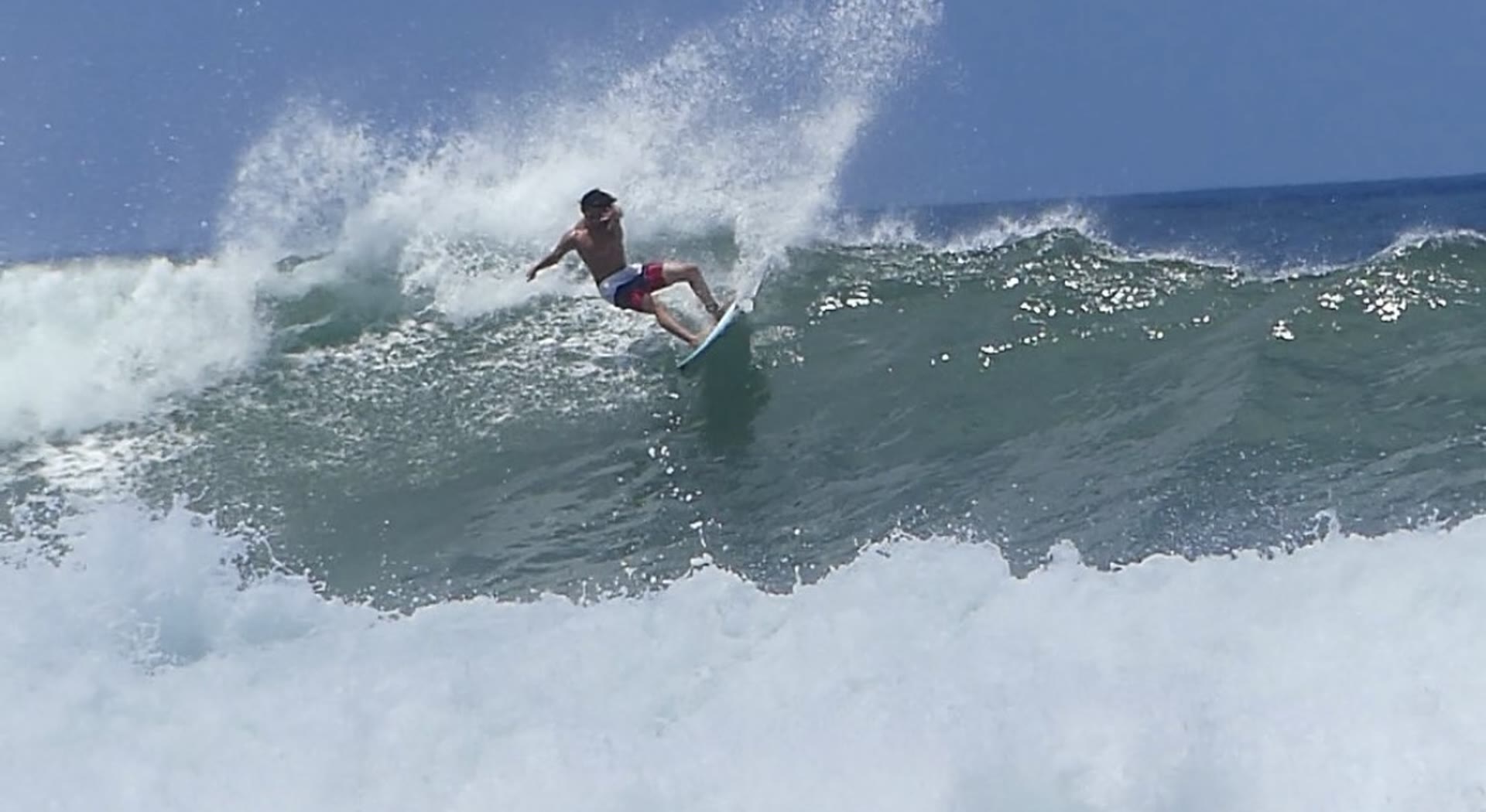 Surfer snapping the lip on a bright day