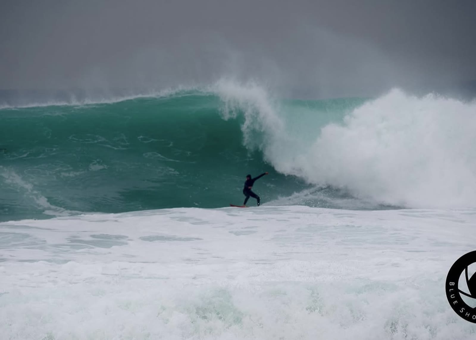 Surfer taking off on a large, heavy wave