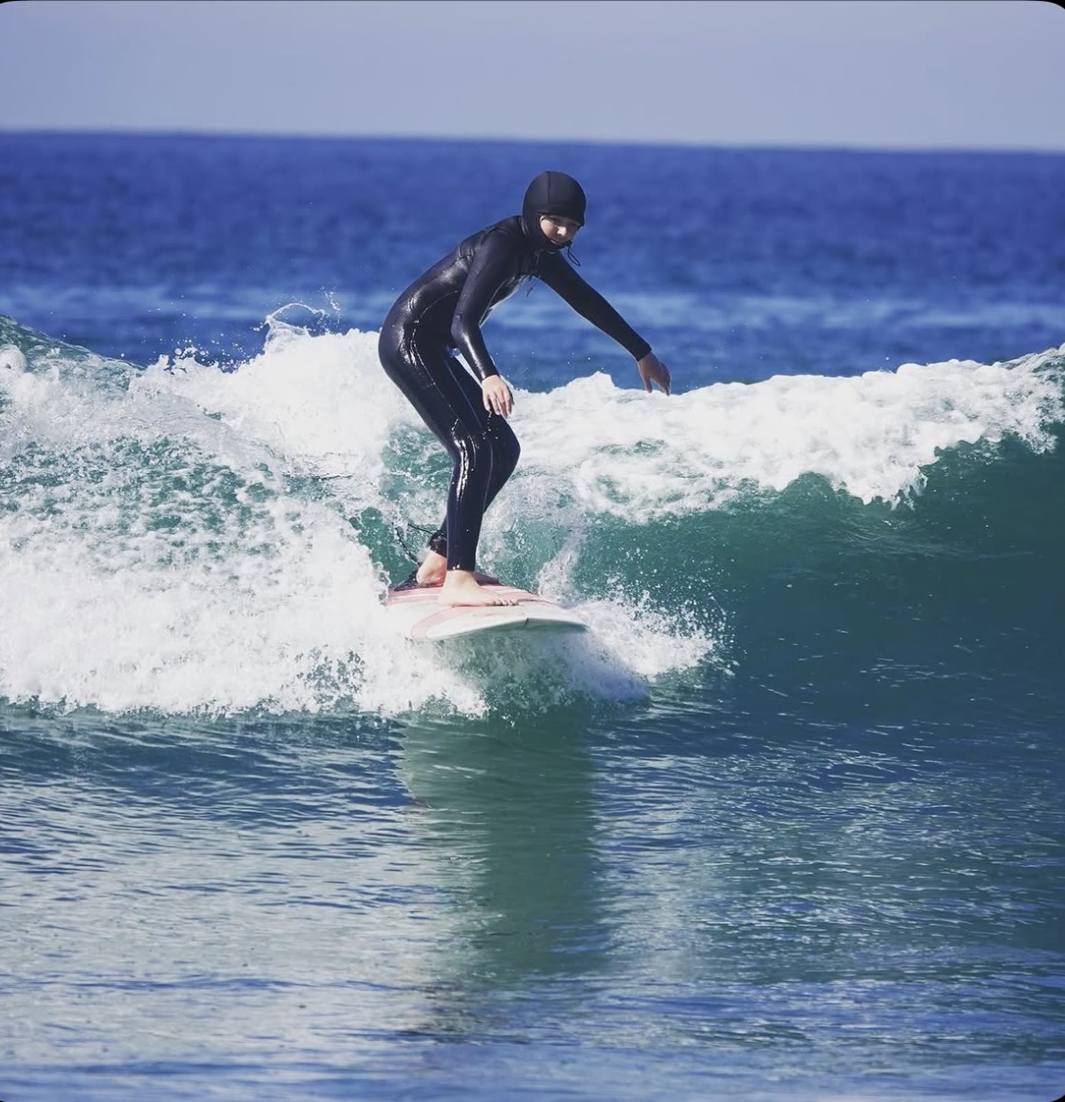 Surfer riding a clean green wave